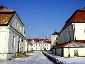 uma fila de edifícios brancos com neve no chão em Apartament 'Aleks' Tykocin em Tykocin