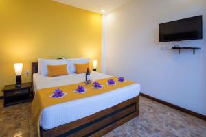 a bedroom with a large bed with purple flowers on it at Ceyloni Panorama Resort in Kandy