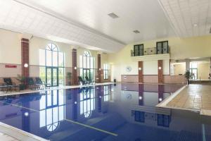 een groot zwembad in een groot gebouw bij Vale Resort in Hensol