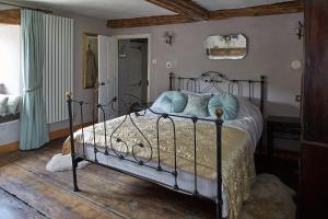 a bedroom with a metal bed with blue pillows at Cherry tree farm B and B in Frome