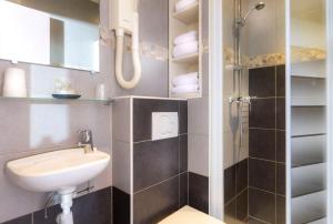 a small bathroom with a sink and a shower at Hôtel Montsouris Orléans in Paris +22 photos