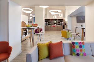 - un salon et une cuisine avec un canapé et des chaises dans l'établissement Hôtel Le Bayonne, à Bayonne