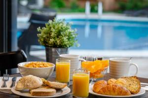 a table topped with breakfast foods and orange juice at Hotel D. Luis - Elvas in Elvas