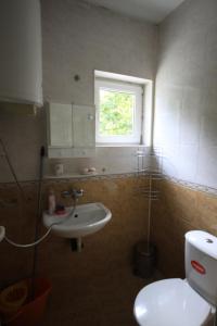 a bathroom with a toilet and a sink and a window at Studios near to Burgas Free University in Burgas City