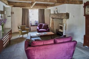 a living room with a purple couch and a fireplace at Cherry tree farm B and B in Frome