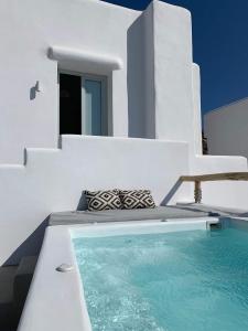 a white house with a swimming pool in front of it at White Loft in Ios Chora