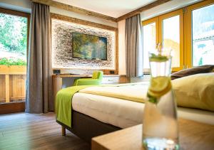 a hotel room with a bed and a vase on a table at AlpinSpa zur Post - Bergbahn im Sommer 2025 inklusive in Bad Gastein +101 photos