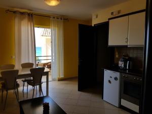 eine Küche und ein Esszimmer mit Tisch und Stühlen in der Unterkunft Corfu Glyfada Menigos Resort 73 in Glyfada