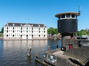 a building next to a body of water with a tower at SWEETS - Kortjewantsbrug in Amsterdam +14 photos