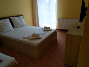 a bedroom with a bed with two towels on it at Casa Crina in Baile Unu Mai