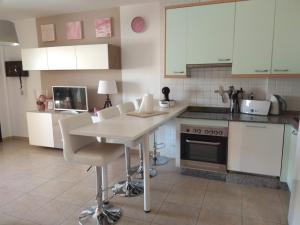 a kitchen with white cabinets and a table and chairs at Residencial Los Geranios 13 in Costa Del Silencio