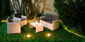 a garden with three chairs and a table with lights at Merlhome in Fondi