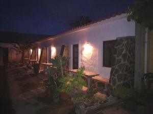 a white house at night with a table and lights at Espaço Pinguim in São Luis