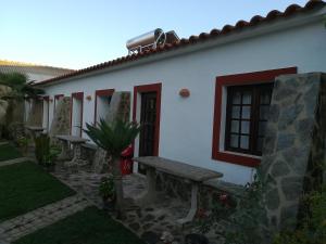 圣路易斯Espaço Pinguim的一座白色的房子，前面有一张长椅