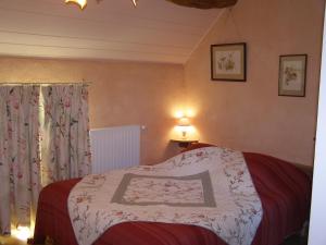 a bedroom with a bed with a white blanket at Gîte des Hortillonnages in Camon