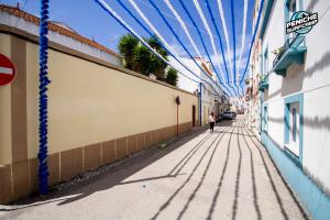 una persona caminando por una calle con un techo azul en Amélia Apartment - Peniche Surf Camp, en Peniche