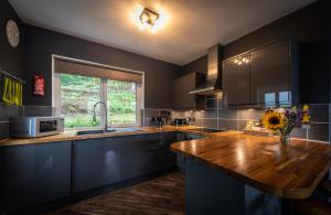 a kitchen with a wooden counter top and a window at Storr Apartments in Portree