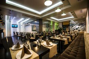 een restaurant met tafels en stoelen in een kamer bij Hotel Aqua in Târgu Jiu