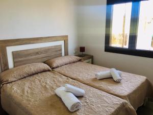 a bedroom with two beds with towels on them at CASA RIBAS in Santa Eularia des Riu