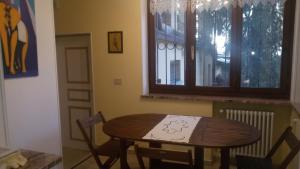 stół i krzesła w pokoju z oknem w obiekcie Casa Zara w Turynie