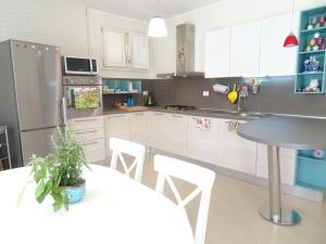 cocina con mesa y nevera en Italy Home en San Costanzo