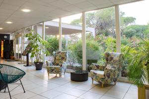 a lobby with chairs and plants in a building at Comfort Aparthotel Frejus La Tour de Mare in Fréjus +33 photos