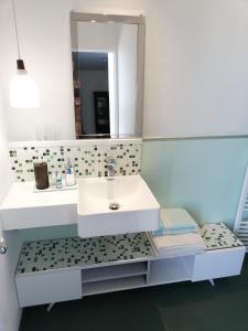 W łazience znajduje się biała umywalka i lustro. w obiekcie Monts Dôme w mieście Clermont-Ferrand