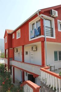 a red and white building with a balcony at Apartments Bordo in Tivat