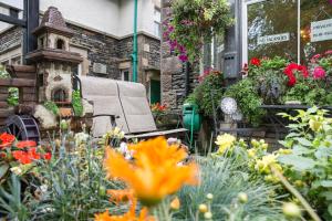 a garden with flowers in front of a building at DUNVEGAN in Windermere
