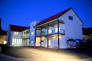 un bâtiment blanc avec un toit rouge la nuit dans l'établissement Hostel Ormož, à Ormoz