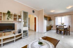 a living room with a television and a dining room at Mare Vista Sea View Apartment in Kali