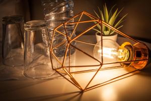 una mesa con tres jarrones de cristal y una lámpara en Lx Center Chiado en Lisboa