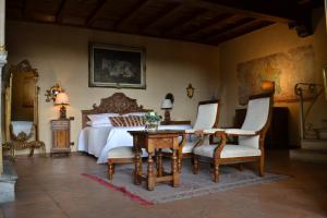 a bedroom with a bed and a table and chairs at Castello di Cernusco Lombardone in Cernusco Lombardone