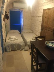 Habitación pequeña con 2 camas y mesa con sidra de mesa en Masseria Oreglia, en Ceglie Messapica