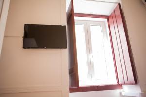 a flat screen tv on a wall next to a window at Lx Center Chiado in Lisbon