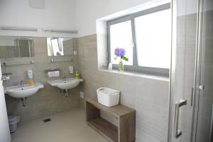 uma casa de banho com 2 lavatórios e uma janela em Hostel Ormož em Ormoz