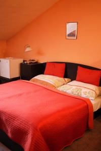 1 Schlafzimmer mit 2 Betten und roten Kissen in der Unterkunft Penzion Tilia in Levice