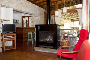 a living room with a fireplace and a television at Cabañas San Dionisio in Mar de las Pampas
