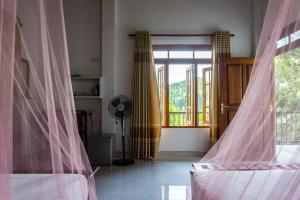 a room with two beds and a window with curtains at Samadhi Nature Resort in Ella