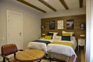 a bedroom with two beds with yellow and blue pillows at La casita de El Cuervo in El Cuervo