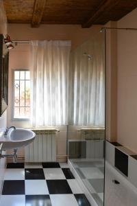 a bathroom with a sink and a glass shower at La casita de El Cuervo in El Cuervo
