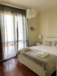sypialnia z łóżkiem i dużym oknem w obiekcie Villa Rosa Charming Flat w mieście Su Forti
