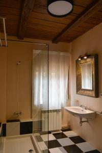 a bathroom with a sink and a glass shower at La casita de El Cuervo in El Cuervo