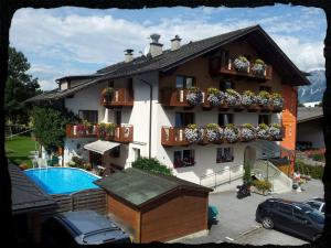 a building with a swimming pool in front of it at B&B Appartements Glungezer in Tulfes