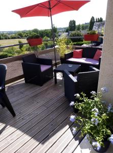 een terras met stoelen en tafels en een parasol bij gite odeau in Sargé-sur-Braye