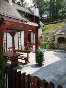 um pavilhão de madeira com uma mesa de piquenique e uma lareira em Holiday House Kod Ajke em Slunj