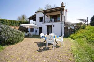 a table with chairs and an umbrella in front of a house at Relais Il Ciliegio in Sorano