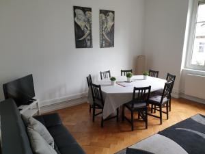 a dining room with a table and a couch at STRASBOURG CENTRE le 85, Superbe F5, 125m2, 5 Pièces in Strasbourg