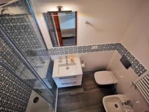 a bathroom with a sink and a mirror and a toilet at Arbanella in Corniglia