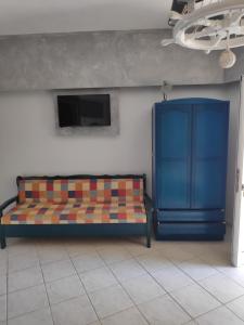 Sofá azul en una habitación con pared en Ilaira Apartments, en Khránoi
